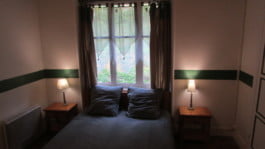 Chambre d'hôtes aux murs blanc et lampes alumées