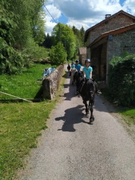 Quantre enfants traversant un hameau de Vollore-Montagne à cheval